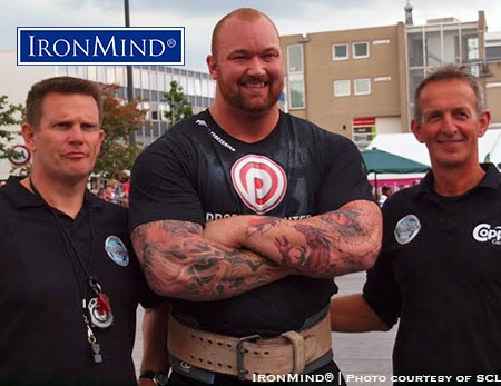 American strongman fans who wish they had access to more strongman coverage on TV should watch for the broadcast of SCL–Holland, coming up on Monday. In the photo, Hafthor Julius Bjornsson is flanked by Dutch referees Berend Veneberg (left) and Fokko de Jong (right). IronMind® | Image courtesy of SCL
