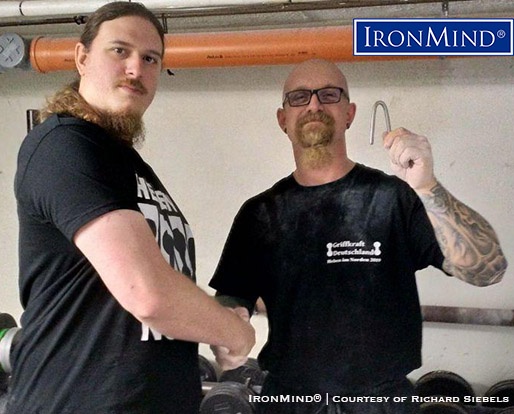 It started off as rehab and grew into a passion for lower arm and grip strength: Richard Siebels (right) has just been certified on the Red Nail, a benchmark short steel bend. Siebel’s official attempt to bend an IronMind Red Nail was refereed by Simon Mahalsky (right), who, incidentally, is certified on the Captains of Crush No. 3 gripper. IronMind® | Courtesy of Richard Siebels