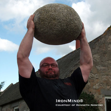 Andy Cairney puts the Inver Stone overhead in commanding style.  IronMind® | Photo courtesy of Kenneth Nowicki.
