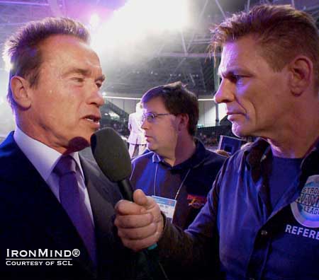 SCL co-founder Marcel Mostert (right) interviewed Arnold Schwarzenegger (left), who presented the winner’s check to Zydrunas Savickas.  IronMind® | Courtesy of SCL.   