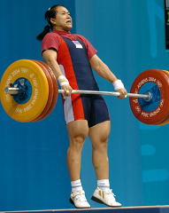 Pawina Thongsuk (Thailand) finishes her pull on this 150-kg clean and jerk, good enough for the gold medal, and an Olympic record in the clean and jerk. IronMind® | Randall J. Strossen, Ph.D. photo.
