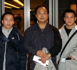 Coach Chen Wenbin (center) and his two Olympic gold medalists, Shi Zhiyong (left) and Zhang Guozheng (right) arrive at Chicago's O'Hare International Airport yesterday. IronMind® | Randall J. Strossen, Ph.D. photo.