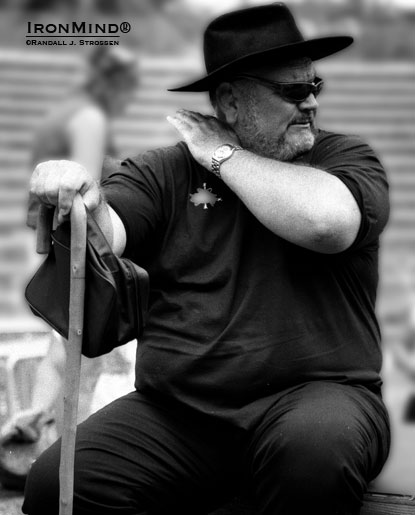 “Get me a cold one and be fast about it!” seems like the perfect caption as Douglas Edmunds referees at Odd Haugen’s 2001 Beauty and the Beast strongman contest.  IronMind® | Randall J. Strossen photo. “Get me a cold one and be fast about it!” seems like the perfect caption as Douglas Edmunds referees at Odd Haugen’s 2001 Beauty and the Beast strongman contest.  IronMind® | Randall J. Strossen photo.