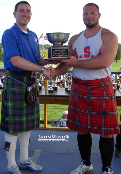 Jonathan Finnie (Board of Directors Scottish Games Society of Delaware) presents the champion’s trophy to Gregor Edmunds at the 51st Annual Colonial Highland Games.  IronMind® | Courtesy of Jonathan Finnie.