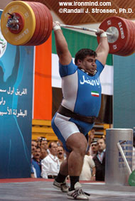 Two-time Olympic gold medalist Hossein Rezazadeh punches up a 260-kg clean and jerk at the 2005 Asian Weightlifting Championships (Dubai, United Arab Emirates). IronMind® | Randall J. Strossen, Ph.D. photo.