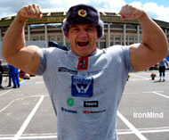 Three-time World's Strongest Man winner Mariusz Pudzianowski, modeling a Russian Army hat, hits a double biceps pose in front of Moscow's Olympic Stadium. IronMind® | Colin Bryce photo.
