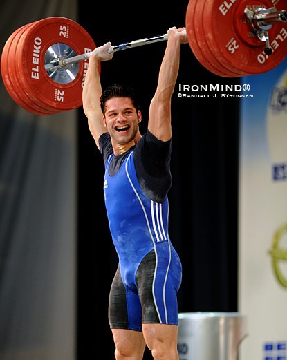 Having just gone six-for-six and pocketing all three gold medals in the men’s 69-kg category at the 2010 European Weightlifting Championships, Ninel Miculescu gives his coaches a big smile after punching this 180-kg clean and jerk overhead.  IronMind® | Randall J. Strossen photo.