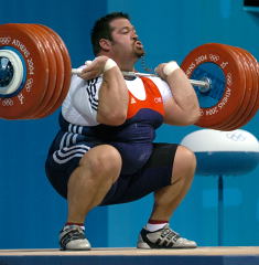 USA Weightlifting cover guy Shane Hamman hits the bottom with with this 237.5-kg clean and jerk at the 2004 Olympics - the biggest clean and jerk ever by an American, and Hamman made it look light (Athens, Greece). IronMind® | Randall J. Strossen, Ph.D. photo.
