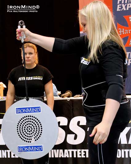 With Jaana Tanner cheering her on, Yvonne Häkkinen hit a very impressive 18.00 seconds on the CoC Silver Bullet Hold (using a Captains of Crush No. 2 gripper) at last weekend’s IronMind Grip Class Semi-Finals (held at the Finnish Fitness Expo).  IronMind® | Photo by Piia Aaltokoski, courtesy of United Strongmen®.