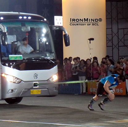Using just an IronMind pulling harness and no rope, Jarno Hams broke the Guinness world record in the bus pull in Beijing.  IronMind&reg; | Courtesy of SCL.